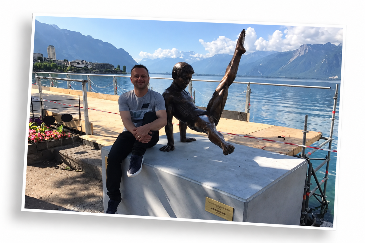 Yves Depallens seated beside a gymnast sculpture on the Montreux lakeside promenade, with Lake Geneva and the Alps in the background.