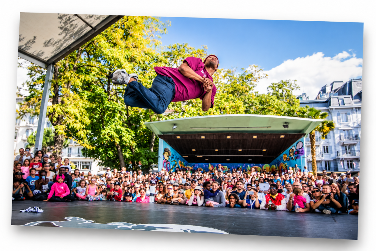 An acrobat performs a spectacular aerial move in front of a large audience during Montreux Acrobaties, on an outdoor stage in Montreux.